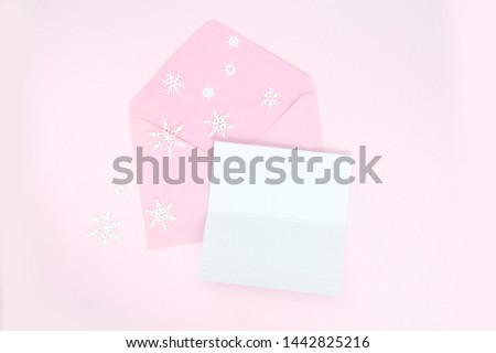 Opened pink envelope with christmas snowflakes and blank paper sheet for your text for greeting card