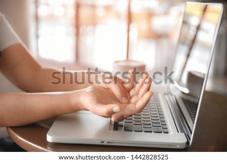 Woman holding her hand pain from using computer long time. Office syndrome concept.