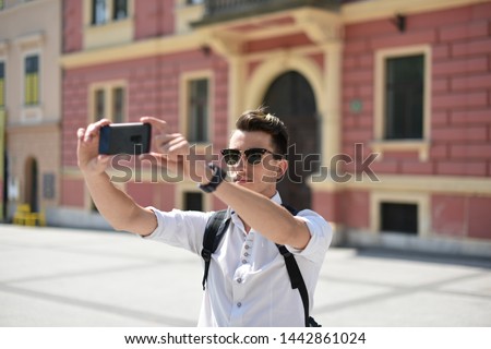 Student / tourist taking photos with smartphone in the European city