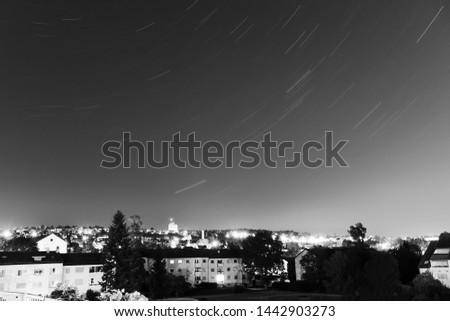 Star traces  in the night sky over the city.