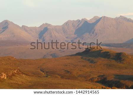 View of Coire na Creiche in the Black Cuillin from the north-west on the slopes of Roineval. The  rays of the setting sun reddens and enhances the contours  of the rugged slopes.