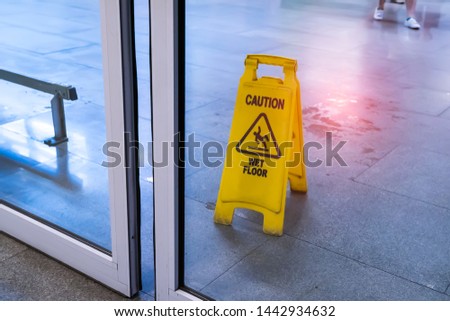 Yellow Caution wet floor sign on wet floor