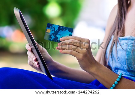 woman hand holding credit card and tablet close up outside