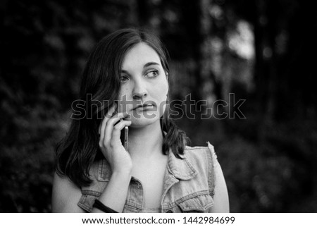 Girl talking on the phone and sad. Sad news. Expectation. How boring. Brown hair with blue eyes. Black-white. Photo.
