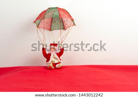 Santa Claus, parachute, sitting deep red. White background for your text space. Christmas card.