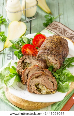 Stuffed Meat Roll with Pear and Cheese on a festive Thanksgiving Day table.