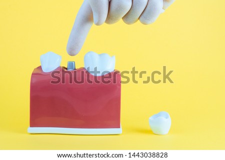False mouth on yellow background with hand working