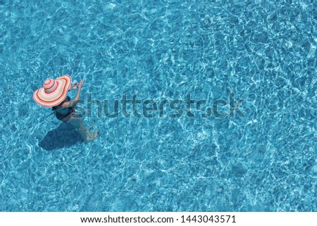 Girl with a big hat in the pool