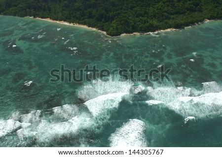 Aerial view of white waves coming to island shore. Bocas del Toro archipelago, Panama, Caribbean, Central America.
