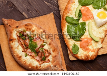 Traditional Georgian dishes, khachapuri and salmon pie and avocado on wooden background