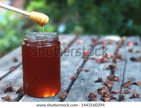 honey flowing from jar and spoon Royalty-Free Stock Photo #1443160394
