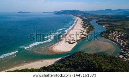 Aerial view of long, narrow sandy beach between ocean and river