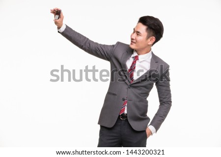 Smiling Asian businessman selfie his photo by smartphone isolated on white background.