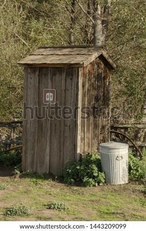 Wooden Old Park Outhouse with Trashcan and Sign