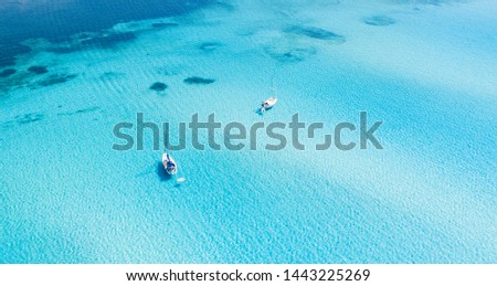 View from above, stunning aerial view of some boats sailing on a beautiful turquoise clear water. Spiaggia La Pelosa (Pelosa beach) Stintino, Sardinia, Italy. Royalty-Free Stock Photo #1443225269