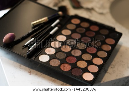 Photo of neutral makeup pallette sitting on the countertop on wedding day