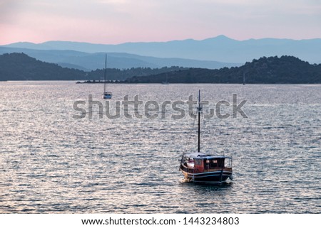 Beautiful colours during sunset with boats cruising the calm sea