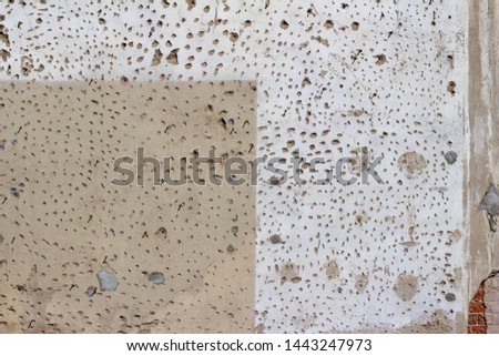 Grungy old distressed cement covered brick wall background with surface holes and deterioration