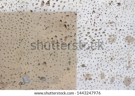 Grungy old distressed cement covered brick wall background with surface holes and deterioration