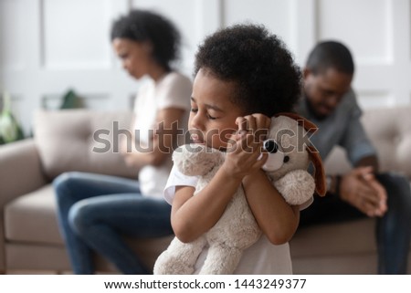 Hurt sensitive little biracial boy hug favorite plush toy suffering from family conflict and fight, sad small kid hold embrace stuffed dog feel lonely being victim of parents arguments or split Royalty-Free Stock Photo #1443249377