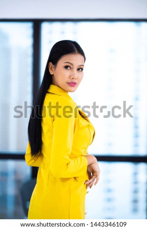Portrait of smiling pretty young business woman wear yellow dress on workplace
