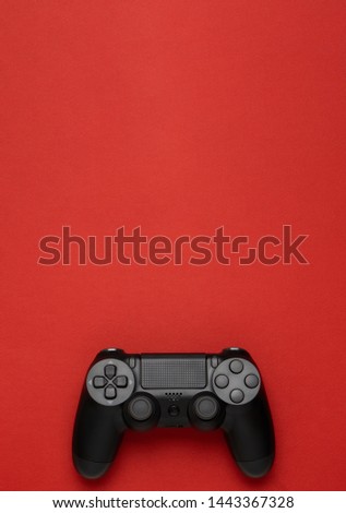 Black gamepad on a red background. Gaming concept. 