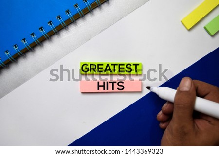 Greatest Hits text on sticky notes with color office desk concept