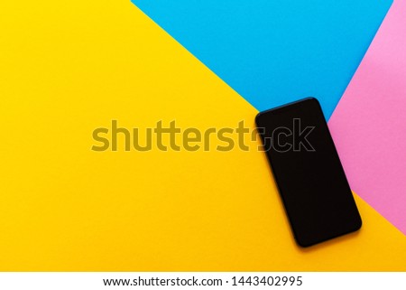 New modern black phone on colorful background, flat lay, copy space
