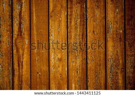 old wooden yellow or brown fence with colorful  paint.aged wood surface painted in yellow colors