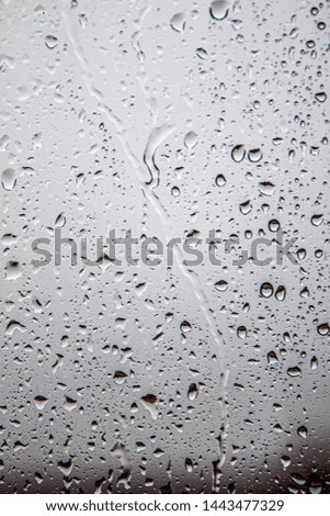 Background rain on the glass. Rain drops on window glasses surface with cloudy background . Natural Pattern of raindrops isolated on cloudy background.