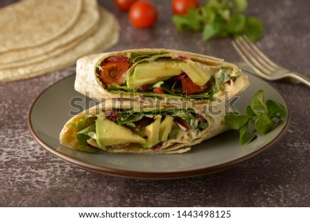 Tortilla wraps with avocado, cherry tomato. Healthy, vegan food. Take away snack, isolated