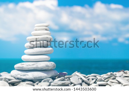 A stack of round pebbles on background the blue sky