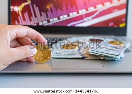 Bitcoin price increase chart. Bitcoins growth chart. Bitcoins and New Virtual money concept. Growth bitcoins. Dollar bills laying on a laptop with bitcoin charts on a blurred background