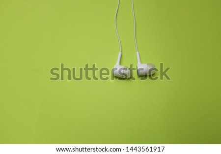 close up and top view White headphones on a green background