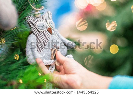 Christmas toy in the hands of a child.Children hands hold the decor at the Christmas tree on which the New Year's toys are hanging . Xmas concept.