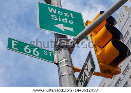 New york city signs and street light post east 66 street arrow pointing to west side one way sign