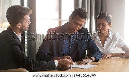Young mixed race ethnicity family couple customers clients sign mortgage loan contract write signature on sale purchase agreement take loan buy insurance meeting bank agent make financial deal Royalty-Free Stock Photo #1443614849