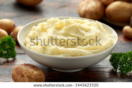 Mashed potatoes in white bowl on wooden rustic table. Healthy food Royalty-Free Stock Photo #1443621920