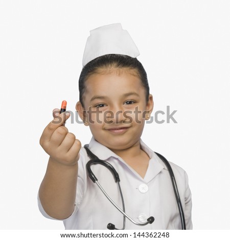 Girl dressed as a nurse and holding a capsule and smiling