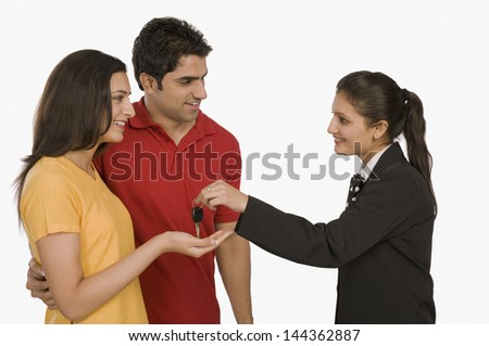 Businesswoman giving a car key to a woman