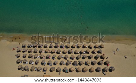 Aerial drone top view photo of sun beds in popular tropical paradise deep turquoise mediterranean sandy beach