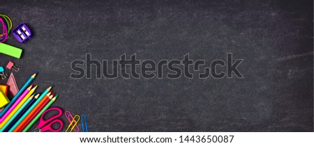School supplies corner border banner. Top view on a chalkboard background with copy space. Back to school concept.