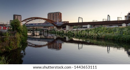 A Northern Rail train crosses the River Irwell between Manchester and Salford on the newly constructed Ordsall Chord railway, part of the "Northern Powerhouse" investment in the North's railways. Royalty-Free Stock Photo #1443653111