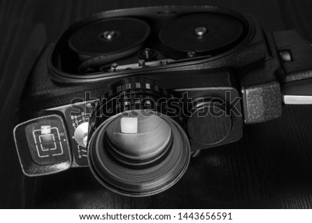 Vintage video camera on a black wooden board. Black and white. Background, wallpaper, copy space.