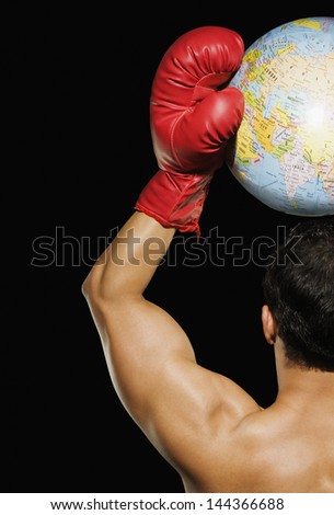 Male boxer holding a globe over his head