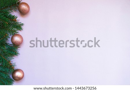 Christmas card concept with fir tree branches and pink shiny balls on light background - text space. Merry Christmas and Happy Holidays greeting card. Flat lay, top view. Copy space for text.