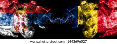 Serbia vs Romania, Romanian smoky mystic flags placed side by side. Thick colored silky smokes combination of Serbian and Romania, Romanian flag