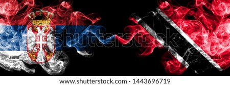 Serbia vs Trinidad and Tobago smoky mystic flags placed side by side. Thick colored silky smokes combination of Serbian and Trinidad and Tobago flag