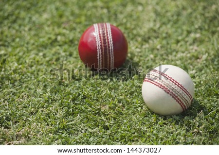 Close-up of two cricket balls on grass