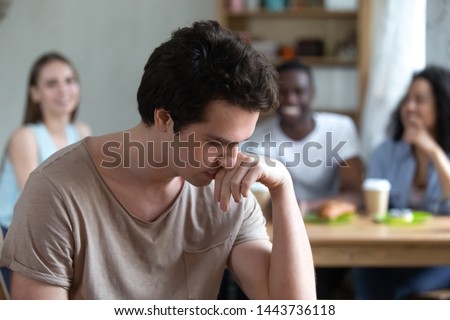 Thoughtful offended by gossips or excluded from company young guy suffering from low self-esteem, unconfident millennial man feeling depressed, hurt by bullying, no friends support or bad friendship. Royalty-Free Stock Photo #1443736118